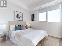 Bedroom with light wood-style flooring, visible vents, and baseboards - 