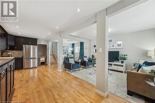 Kitchen featuring recessed lighting, decorative backsplash, light wood-style floors, freestanding refrigerator, and open floor plan - 315 Berkindale Drive, Hamilton, ON - Indoor Photo Showing Other Room