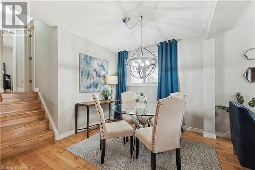 Dining space with an inviting chandelier, stairs, baseboards, and hardwood / wood-style floors - 315 Berkindale Drive, Hamilton, ON - Indoor Photo Showing Dining Room