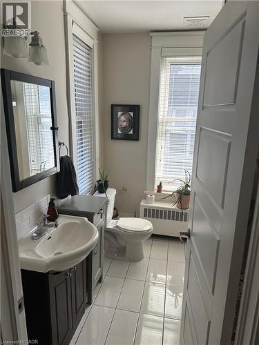 Half bathroom featuring radiator heating unit, vanity, plenty of natural light, and tile patterned flooring - 58 Madison Avenue N, Kitchener, ON - Indoor Photo Showing Bathroom