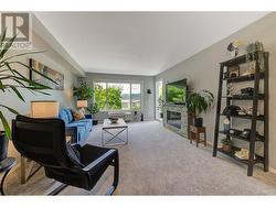 Living room with electric fireplace and newer carpet plus access to covered deck - 