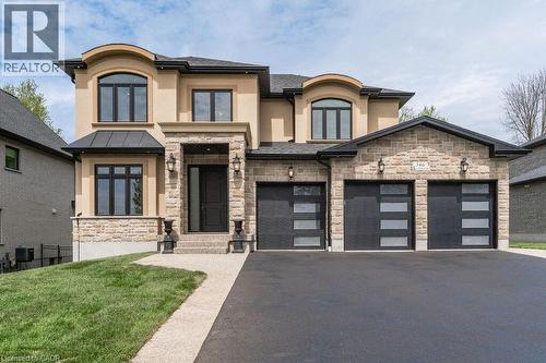 View of front of home featuring stone siding, stucco siding, driveway, a front lawn, and french doors - 346 Lexington Road, Waterloo, ON - Outdoor With Facade