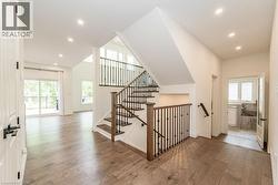 Stairway featuring wood-type flooring, plenty of natural light, recessed lighting, and baseboards - 