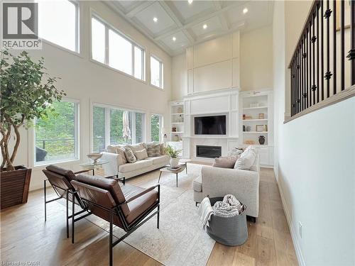 Living room featuring a high ceiling, light wood-style flooring, coffered ceiling, healthy amount of natural light, and recessed lighting - 346 Lexington Road, Waterloo, ON - Indoor Photo Showing Living Room With Fireplace