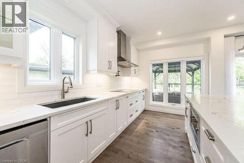 Kitchen with a sink, wall chimney exhaust hood, dishwasher, white cabinets, and black electric stovetop - 346 Lexington Road, Waterloo, ON - Indoor Photo Showing Kitchen With Upgraded Kitchen
