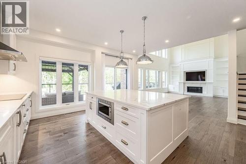 Kitchen with stainless steel microwave, recessed lighting, black electric cooktop, dark wood-style floors, and a glass covered fireplace - 346 Lexington Road, Waterloo, ON - Indoor Photo Showing Kitchen With Upgraded Kitchen