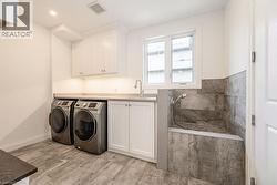 Washroom with washer and clothes dryer, cabinet space, and baseboards - 