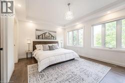 Bedroom featuring baseboards, wood finished floors, a chandelier, ornamental molding, and recessed lighting - 