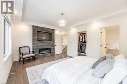 Bedroom featuring baseboards, multiple windows, wood finished floors, a closet, and crown molding - 