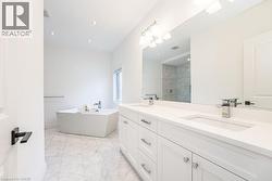 Full bathroom featuring tiled shower, a soaking tub, double vanity, marble finish floors, and recessed lighting - 