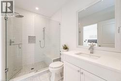 Bathroom featuring toilet, a stall shower, vanity, marble finish flooring, and recessed lighting - 