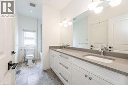 Bathroom with double vanity, toilet, shower / washtub combination, and recessed lighting - 