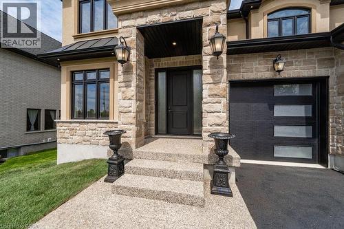 View of exterior entry with stone siding, a standing seam roof, asphalt driveway, and metal roof - 346 Lexington Road, Waterloo, ON - Outdoor With Facade