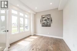 Unfurnished room with healthy amount of natural light, light wood-style floors, recessed lighting, and baseboards - 