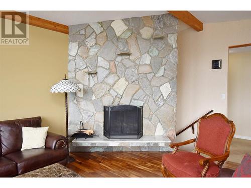 Stone fireplace in living room - 9003 Cherry Lane, Coldstream, BC - Indoor Photo Showing Living Room With Fireplace