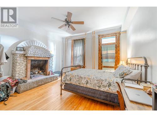 Main Floor Bedroom 2 with Fireplace - 304 Second Street E, Revelstoke, BC - Indoor Photo Showing Bedroom With Fireplace