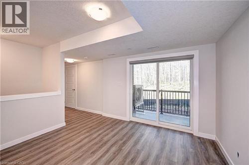 Unfurnished room featuring a textured ceiling and wood finished floors - 118 Gravel Ridge Trail Unit# A9, Kitchener, ON - Indoor Photo Showing Other Room