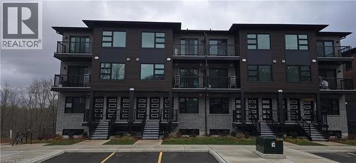 View of building exterior featuring uncovered parking - 118 Gravel Ridge Trail Unit# A9, Kitchener, ON - Outdoor With Balcony With Facade