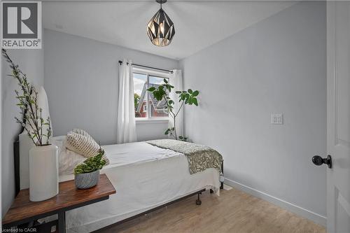 Bedroom with wood finished floors and a chandelier - 47 Gruhn Street, Kitchener, ON - Indoor Photo Showing Bedroom