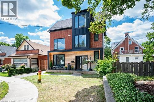 Rear view of property with board and batten siding and brick siding - 47 Gruhn Street, Kitchener, ON - Outdoor With Facade