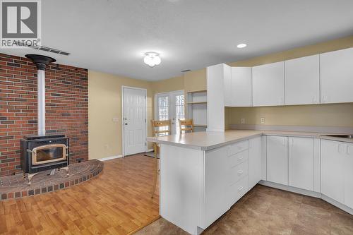 7992 Falcon Ridge Crescent, Kelowna, BC - Indoor Photo Showing Kitchen With Fireplace