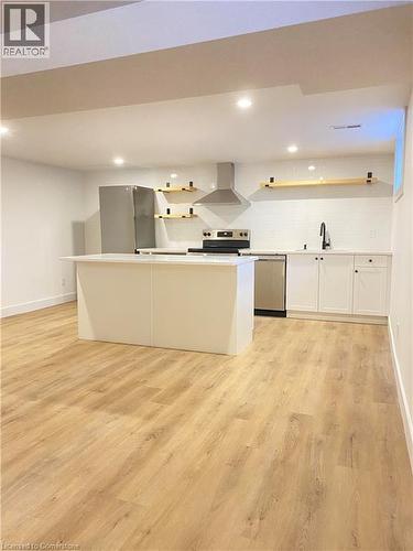 Kitchen with open shelves, recessed lighting, a kitchen island, wall chimney exhaust hood, and white cabinetry - 79 Inwood Crescent, Kitchener, ON - Indoor Photo Showing Kitchen