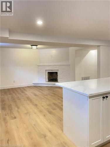 Unfurnished living room with light wood finished floors, a fireplace with raised hearth, and recessed lighting - 79 Inwood Crescent, Kitchener, ON - Indoor Photo Showing Other Room