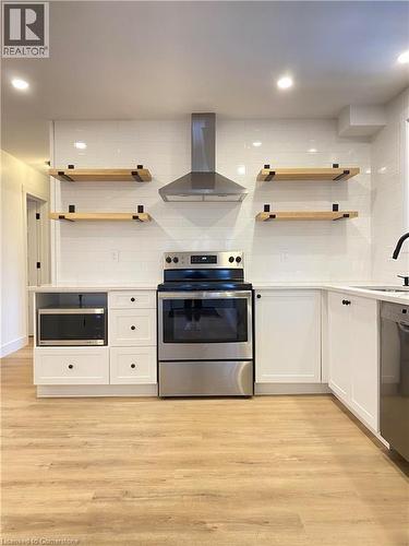 Kitchen featuring stainless steel appliances, wall chimney exhaust hood, white cabinetry, open shelves, and recessed lighting - 79 Inwood Crescent, Kitchener, ON - Indoor Photo Showing Kitchen