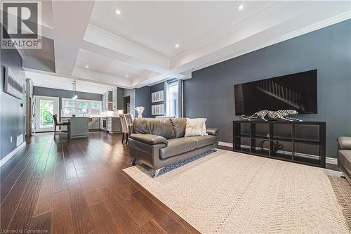 Living room featuring coffered ceiling, beamed ceiling, dark wood-style flooring, crown molding, and recessed lighting - 25 Orchard Hill, Hamilton, ON - Indoor