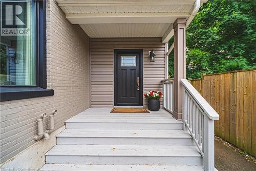 Property entrance with brick siding and covered porch - 25 Orchard Hill, Hamilton, ON - Outdoor With Deck Patio Veranda With Exterior