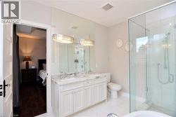 Full bathroom featuring ensuite bathroom, a shower stall, and double vanity - 