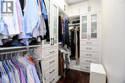 Walk in closet featuring dark wood-style floors - 