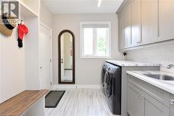 Washroom featuring washing machine and clothes dryer and cabinet space - 