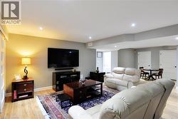 Living room with light wood-style flooring and recessed lighting - 