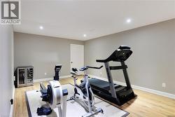 Exercise room with light wood-type flooring, recessed lighting, and wine cooler - 