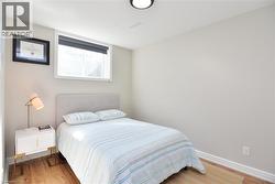 Bedroom featuring light wood-style floors and baseboards - 