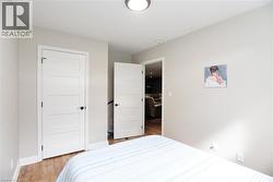 Bedroom featuring light wood-type flooring and baseboards - 