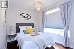 Bedroom with wood finished floors and a chandelier - 