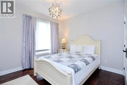 Bedroom with dark wood-style flooring and a chandelier - 