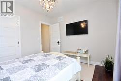 Bedroom with wood finished floors and a chandelier - 