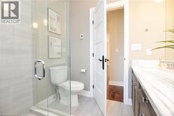 Full bath featuring vanity, a stall shower, and light tile patterned floors - 
