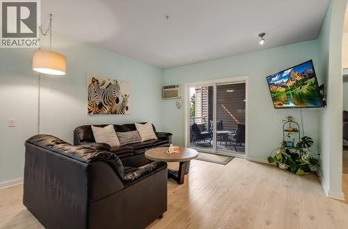 Cozy living area with sliding door onto deck - 151 Taylor Road Unit# 202, Kelowna, BC - Indoor Photo Showing Living Room