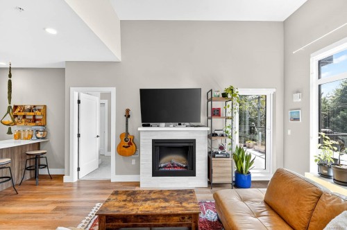 302-700 Yew Wood Rd, Tofino, BC - Indoor Photo Showing Living Room With Fireplace