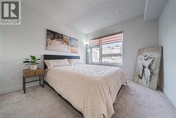 Bedroom featuring light colored carpet and a textured ceiling - 