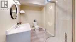 Full bathroom featuring vanity, a shower stall, and light wood-type flooring - 