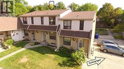 View of front facade featuring a shingled roof, brick siding, and a front lawn - 
