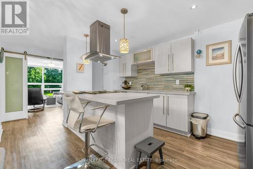 OPEN CONCEPT KITCHEN WITH  ISLAND BAR - 105 - 20 Speers Road, Oakville (Co Central), ON - Indoor Photo Showing Other Room