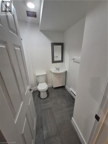 Half bathroom with vanity and a baseboard radiator - 27 Bridge Street Unit# 107, Brantford, ON - Indoor Photo Showing Bathroom