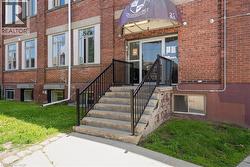 View of exterior entry with brick siding and a lawn - 