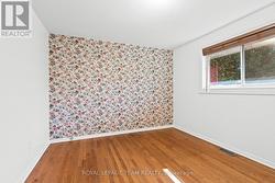 Primary bedroom with hardwood flooring - 